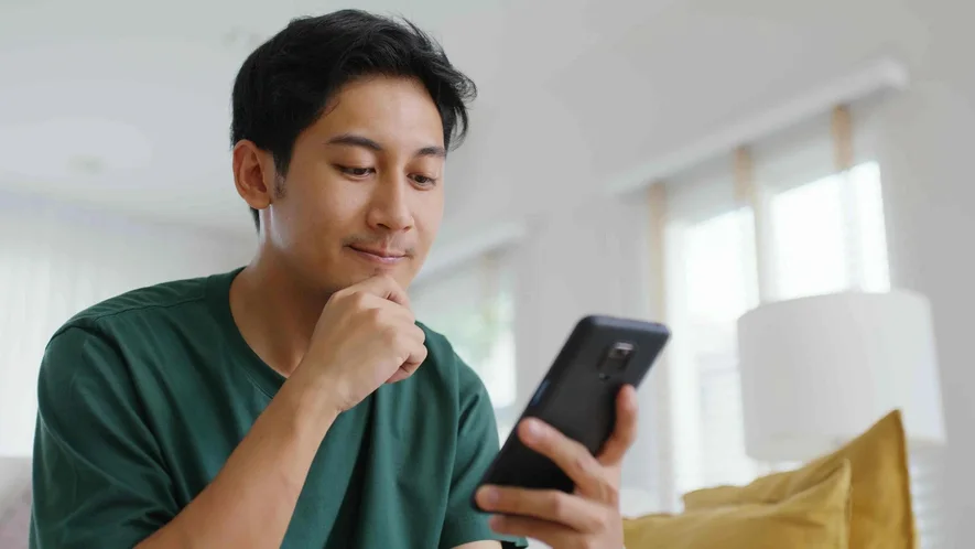 A person comparing online therapy options on a phone