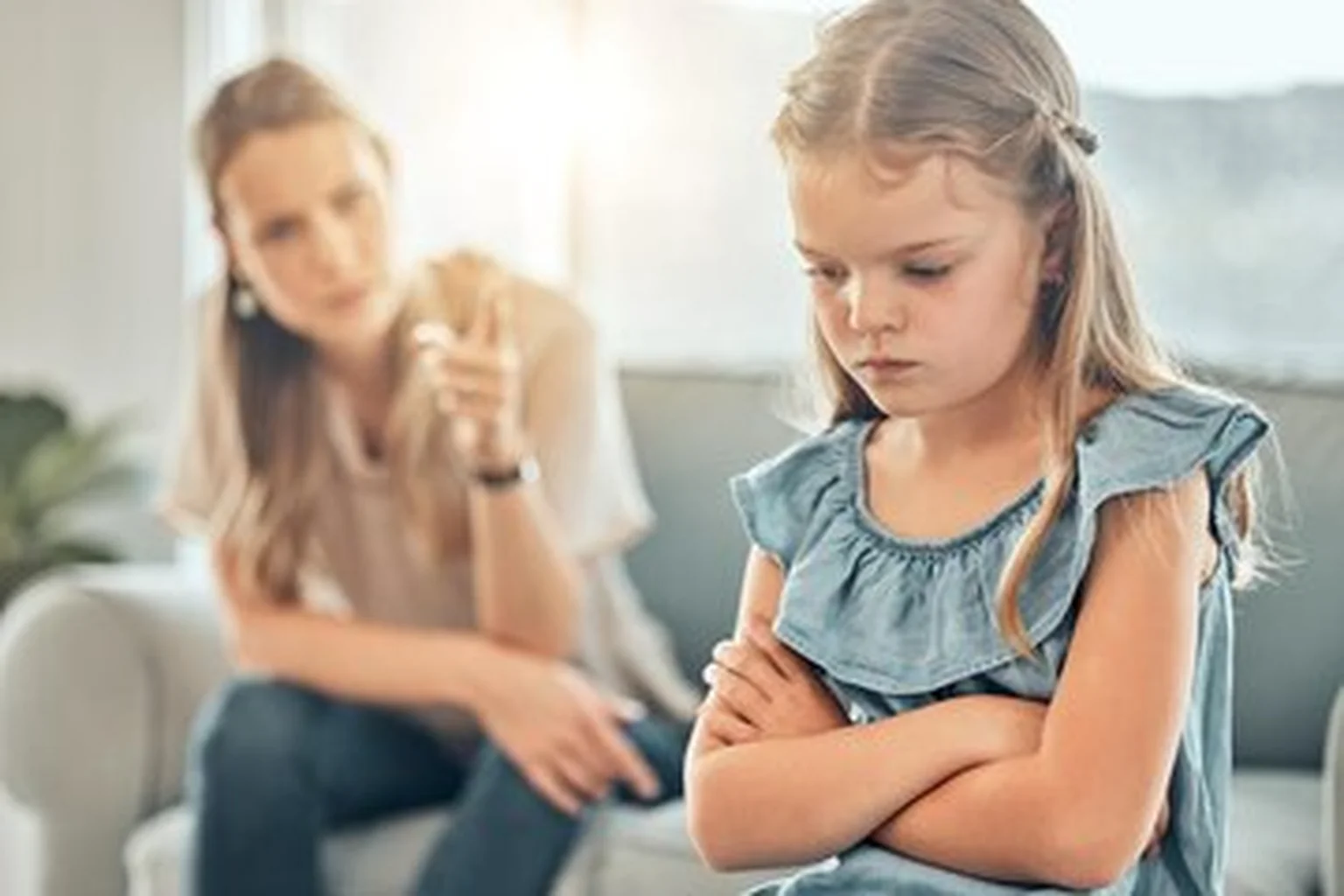 A child expressing anger with a parent nearby