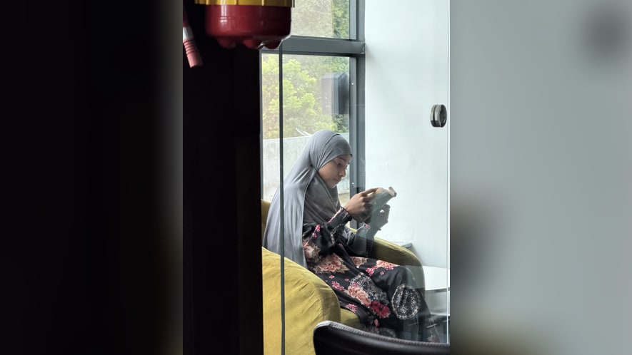 A child sitting by a window reading a book
