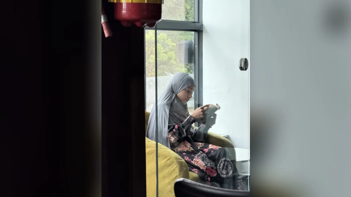A child sitting by a window reading a book